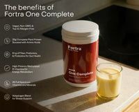 Fortra One Complete supplement container on a kitchen counter with a glass of liquid.