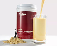 Fortra One Complete supplement container with a glass of vanilla shake and vanilla powder on a white background
